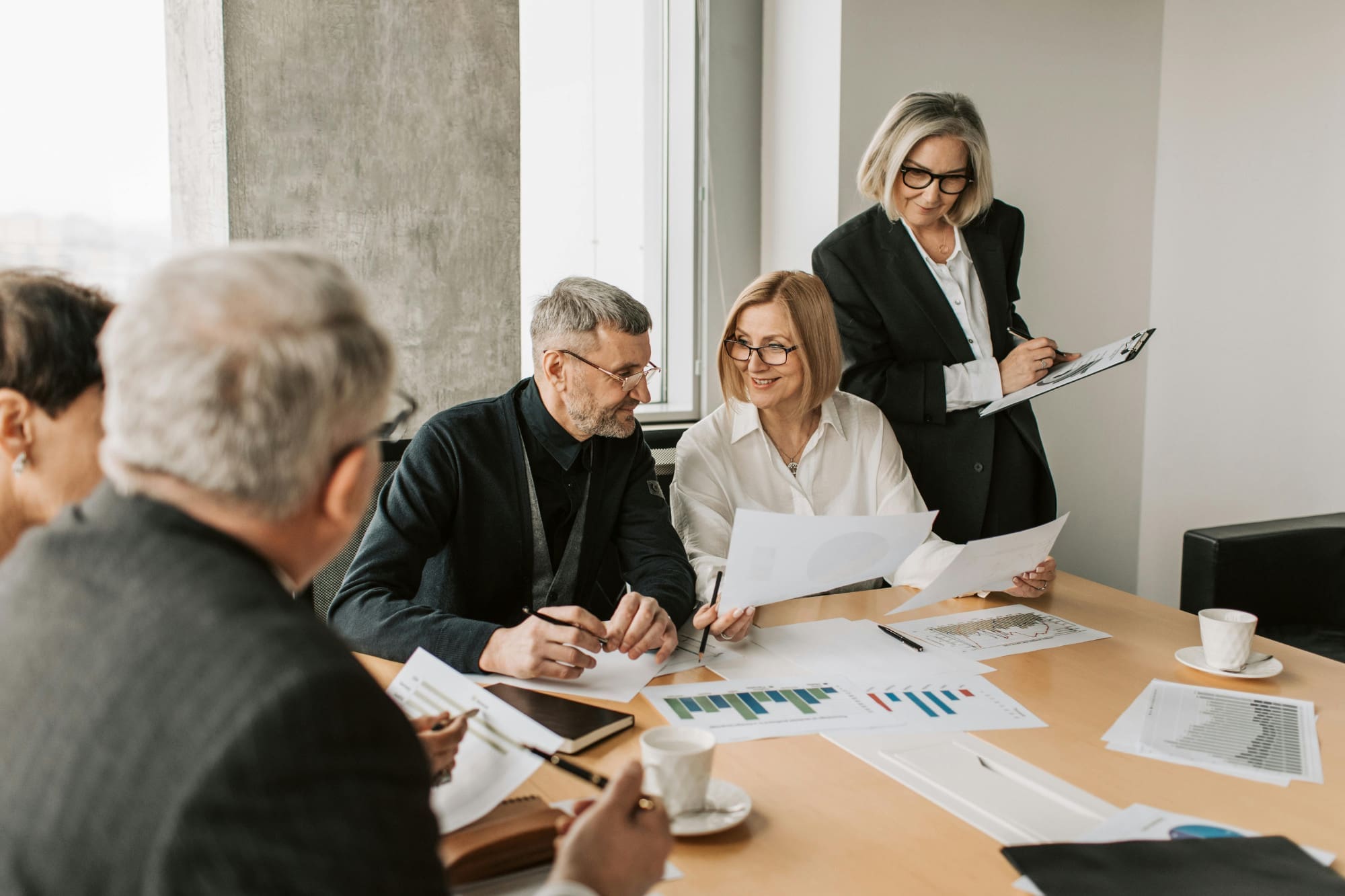 Group of people in office looking through pages and graphs.