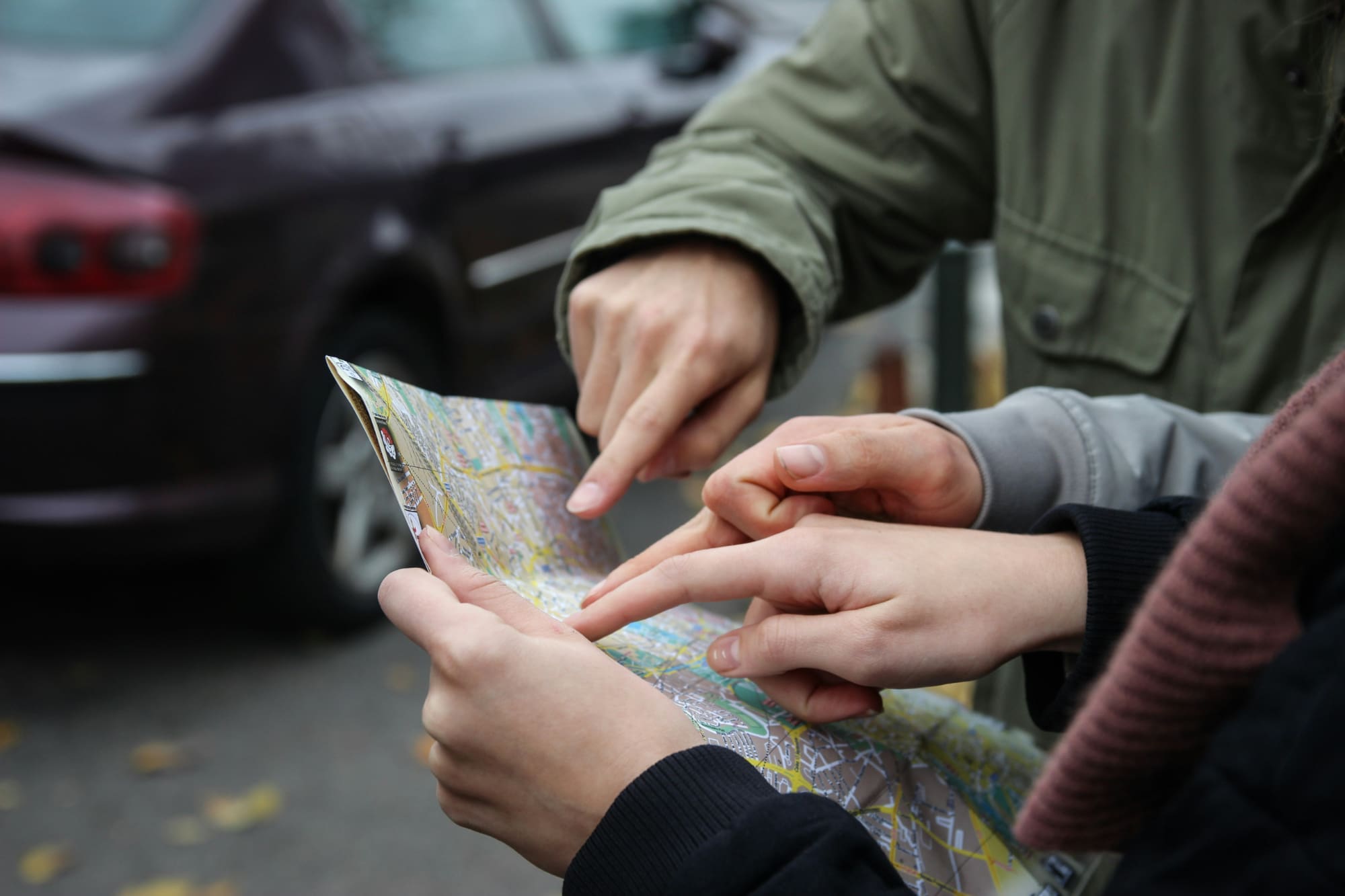 A group of people in the street point at a map.