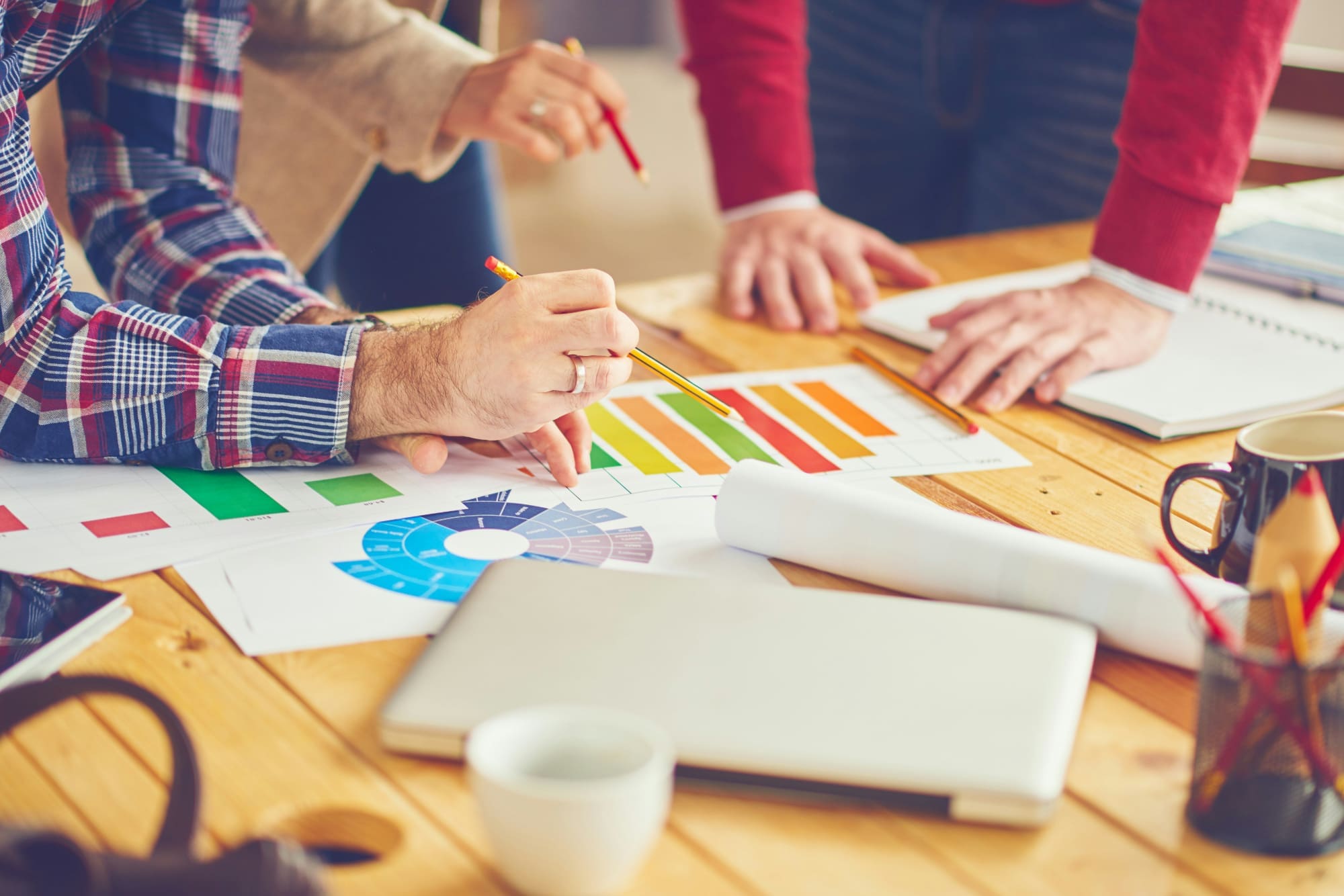 Key features Two office workers sitting at desk pointing at bar charts.