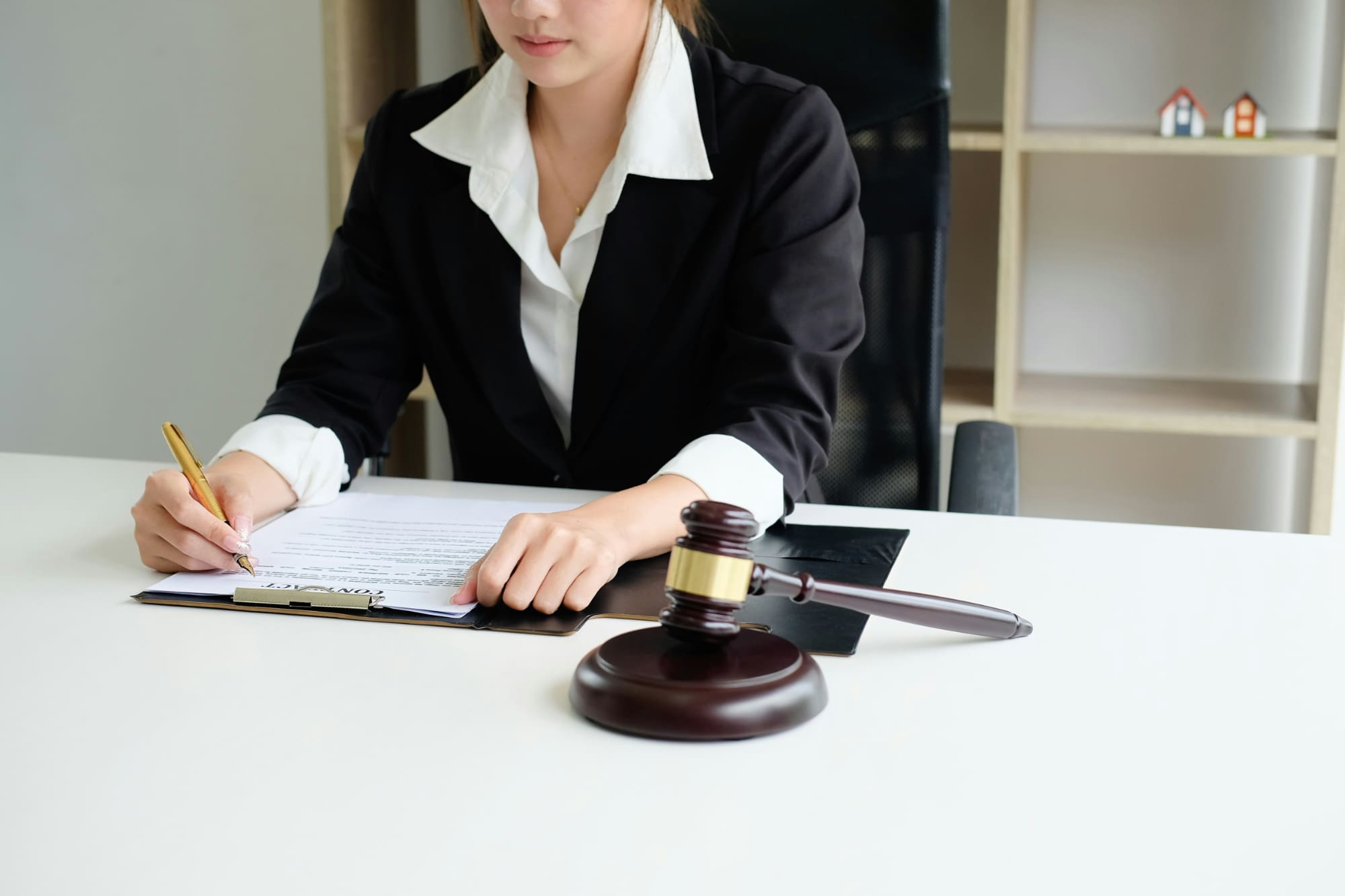 Proven responses Business person writing on notepad with gavel in front of them.