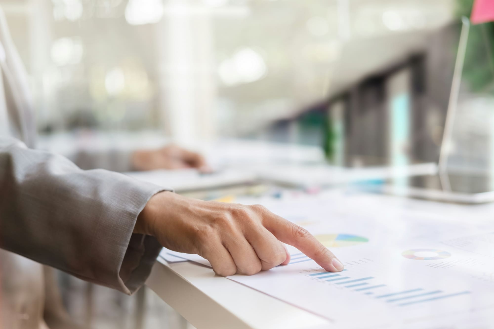 EcoVadis policies Person using finger to point to particular list on a paper document.