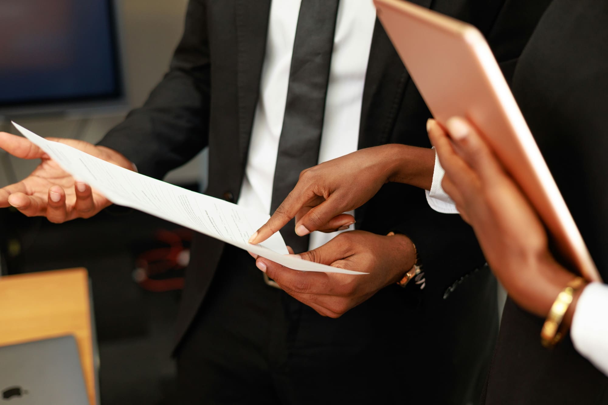 Two business people pointing at document.