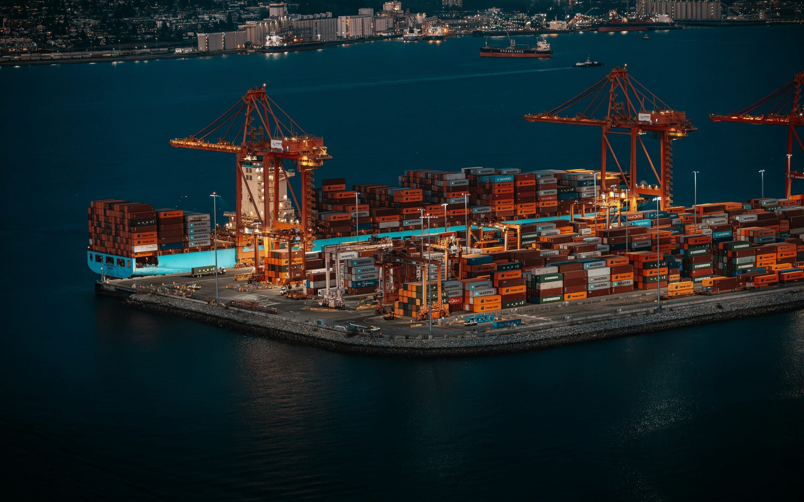 Aerial view of a container port at night, representing supply chain emissions in Scope 3 reporting