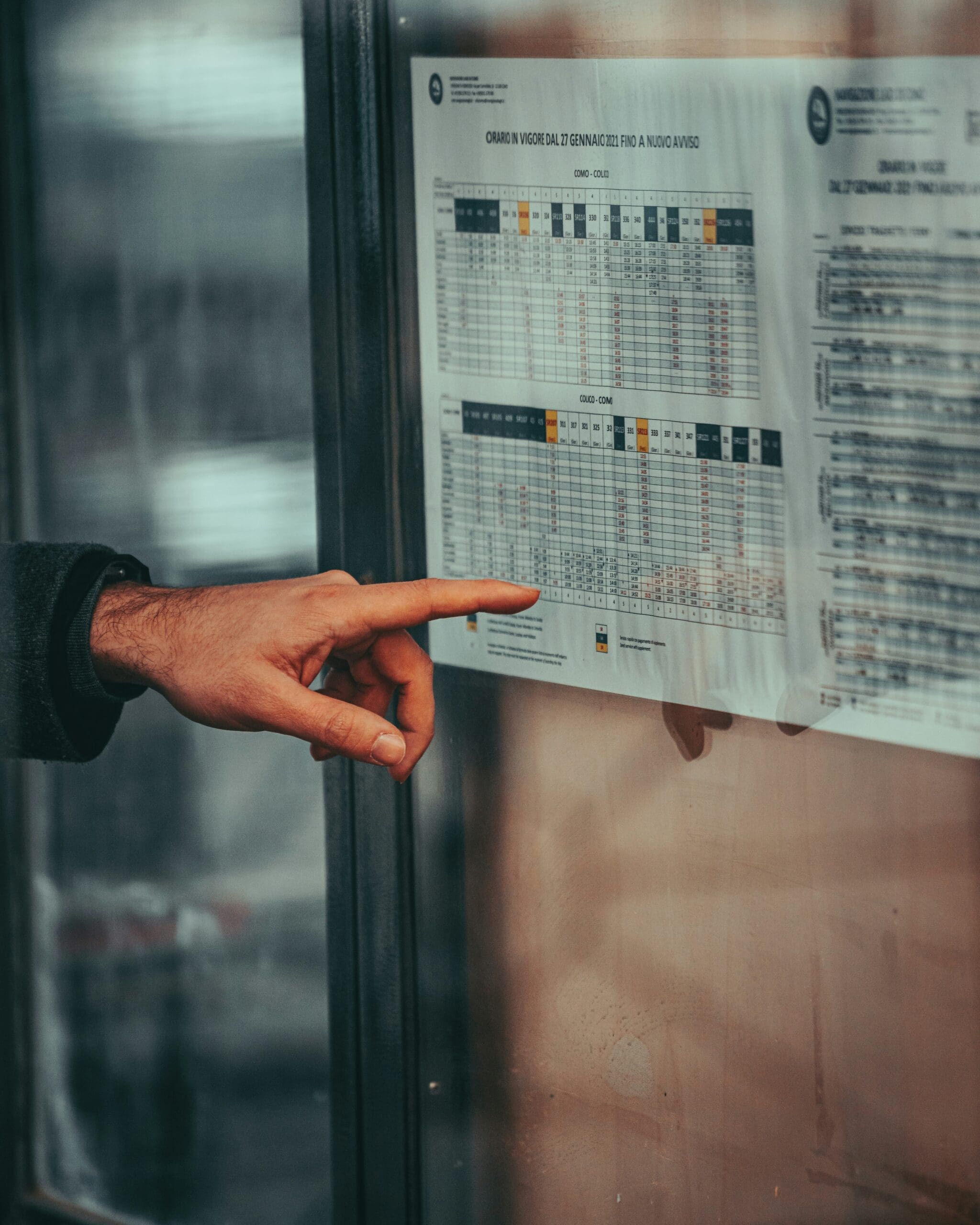 Hand pointing at a detailed data schedule, symbolising how emissions data can inform real business decisions
