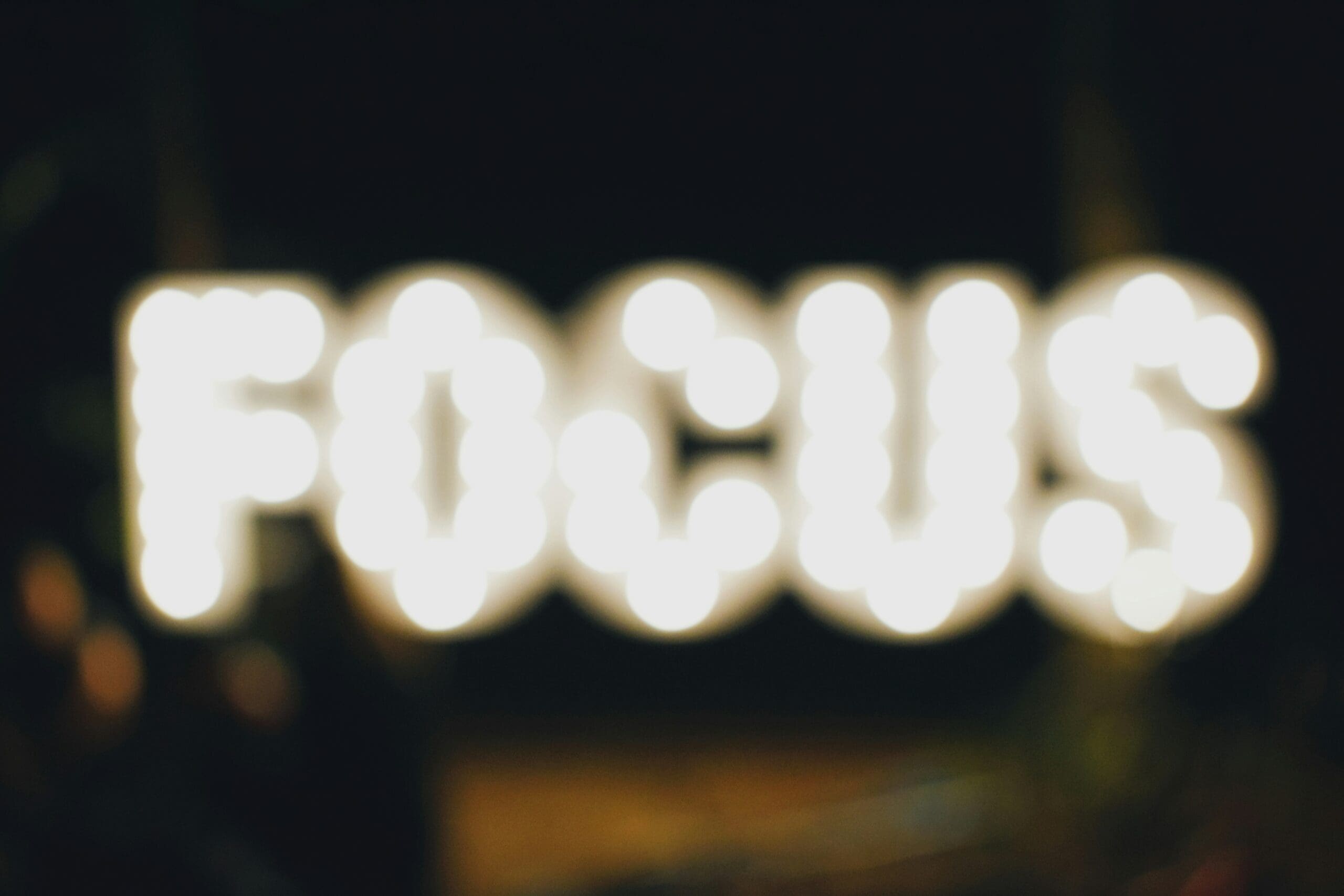 Blurred neon sign spelling FOCUS, illustrating the need to prioritise high-impact Scope 3 emission categories
